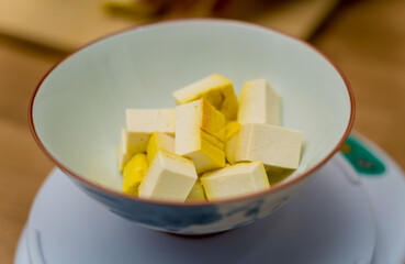 Chef at the kitchen preparing pumpkin porridge with tofu and vegetables