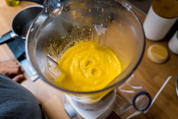 Chef at the kitchen preparing pumpkin porridge with tofu and vegetables