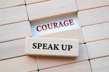 Top view of Courage and Speak Up text on wooden blocks. Speak up concept