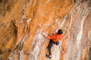 A rock climber climbs a difficult route.