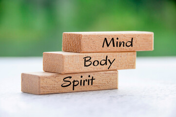 Mind, Body and spirit on wooden blocks with nature background