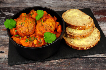Vegetable casserole and dumplings meal with buttered bread slices