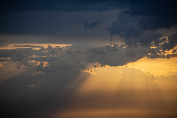 rays of beautiful sun through the clouds and thick fog on the eve of a thunderstorm front and...