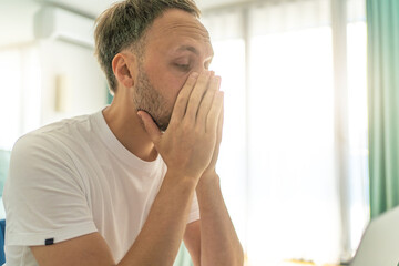 Young man experiencing emotional fatigue and exhaustion at home, mental health issues, stress, and...