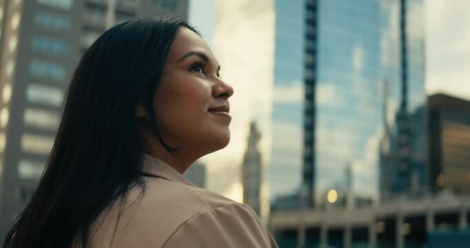Young woman admiring downtown city buildings and scenery during sunset