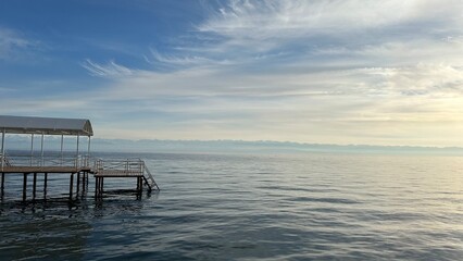 pier over the lake with blue sky with white clouds