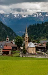 Reformed Church in Bravuogn in Graubunden with the townscape and mountains in the background