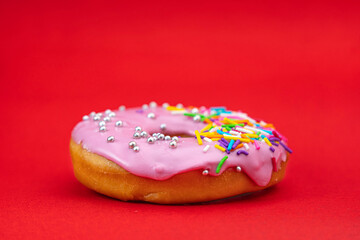 donut with sprinkles on red background