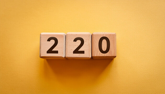 Wooden cubes with number 220 on isolated yellow backdrop. Wood blocks. Close-up. Flat lay