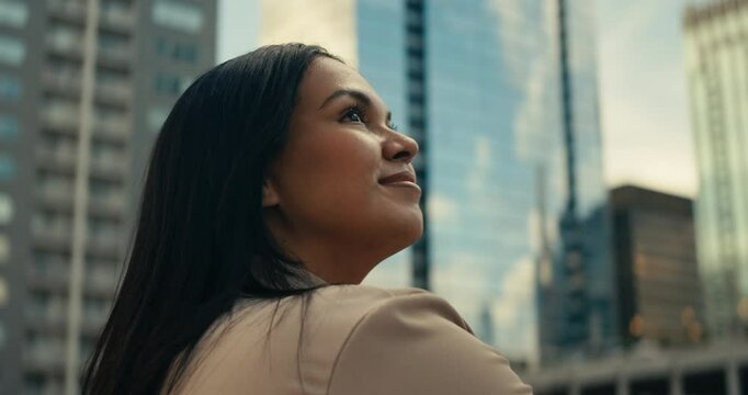 Young woman admiring downtown city buildings and scenery during sunset