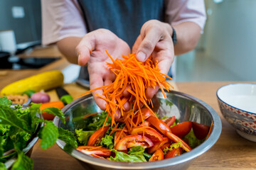 Chef at the kitchen preparing spicy glass noodle salad