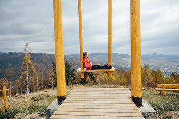 Boy in the mountains on a big swing