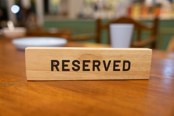 A wooden sign that says reserved is on a table