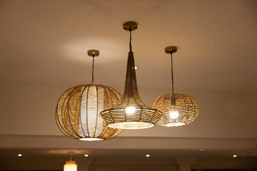 Three lamps hanging from the ceiling, one of which is a large round lamp