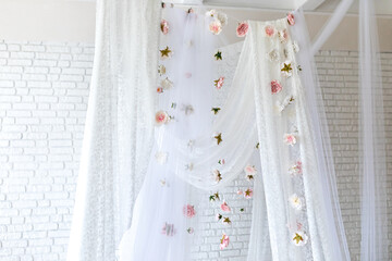 Baldachin on bed. Summer pink peonies and roses flowers levitating, hanging flowers, copy space. Template, mockup. White lace curtains canopy with floral abstract pattern with spring flowers levitate  © stock_studio