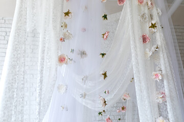 Baldachin on bed. Summer pink peonies and roses flowers levitating, hanging flowers, copy space. Template, mockup. White lace curtains canopy with floral abstract pattern with spring flowers levitate  © stock_studio