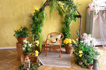 Interior of a wooden greenhouse with rattan chair. Plants and flowers growing in small wooden greenhouse. Wooden rustic arch style, different garden tools and pots. Gardening at home. Wedding decor