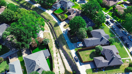 Close-up aerial large opening of concrete channels trench drains in suburban neighborhood, city infrastructure to facilitates drainage from residential street discharge into creek, Coppell, Texas