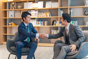 ロビーで握手するエグゼクティブ男性