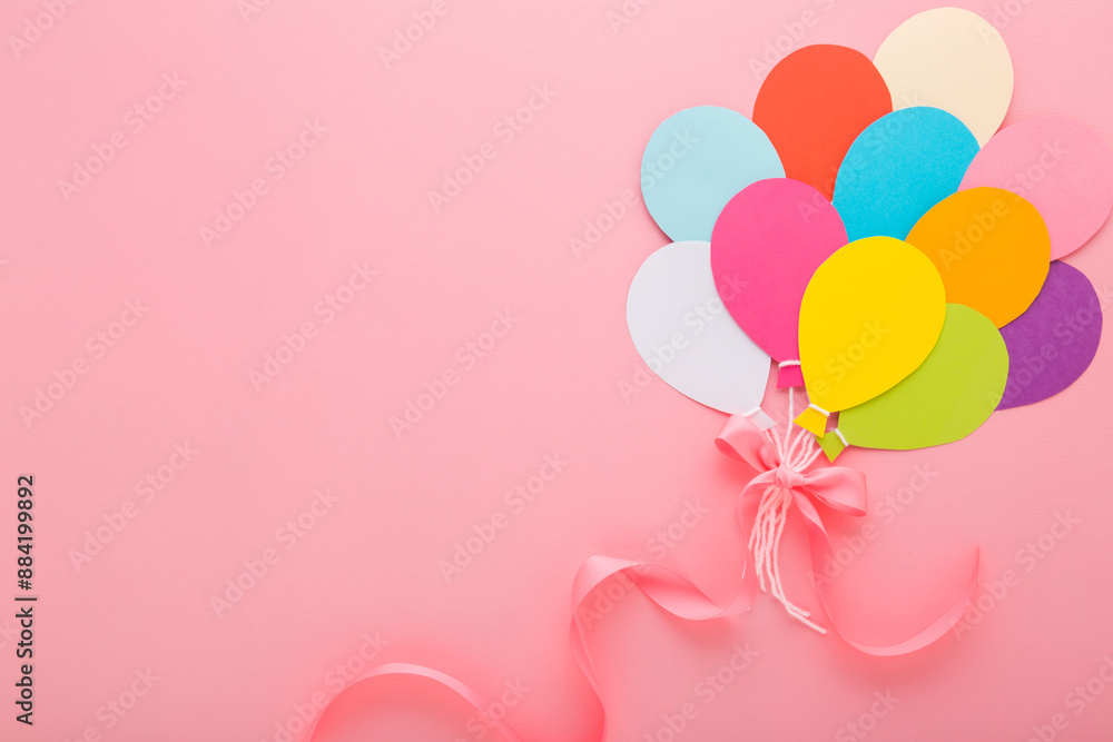 Wall mural bunch of colorful balloon shapes from application paper with white strings and ribbon on light pink 