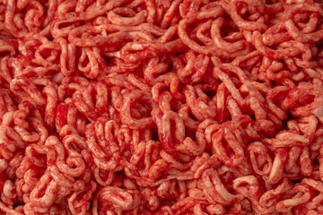Raw chopped meat as a background. Top view.