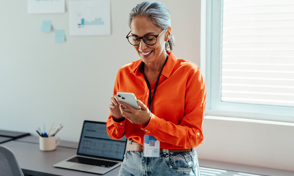 Smiling businesswoman using smartphone in modern office setting