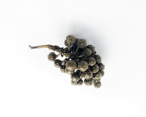 Pile of dried cubeb pepper closeup on white background