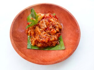 eggplant chili sauce, accompaniment to spicy food. fresh and hot traditional side dish. chili sauce made from eggplant served on a wooden plate against white background. Close up