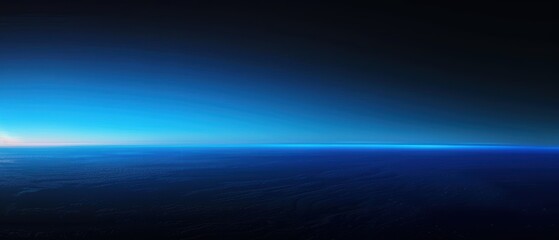 A breathtaking view of sunrise at the edge of Earth's atmosphere, where a thin blue line illuminates the curvature of the planet against the dark space.