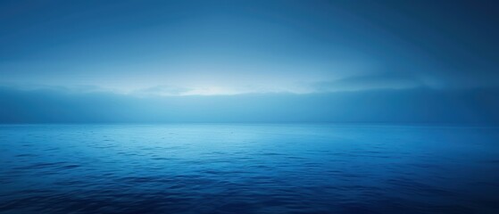 Fototapeta premium A tranquil blue seascape under a cloudy sky at dawn merging sea and horizon.