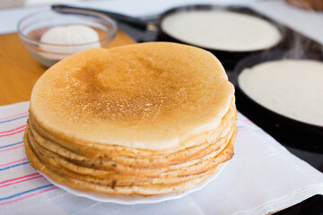 Cooking traditional pancakes from wheat flour in the kitchen