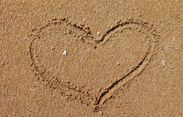 heart drawn or love sign on the sand beach