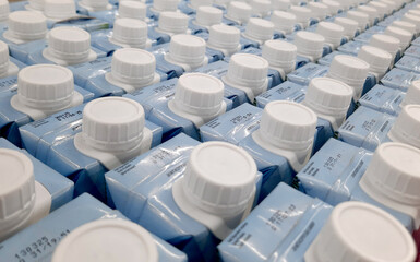 Easy to open screw caps on rows of milk cartoon. Milk cartoon packaging on rows