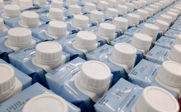 Easy to open screw caps on rows of milk cartoon. Milk cartoon packaging on rows