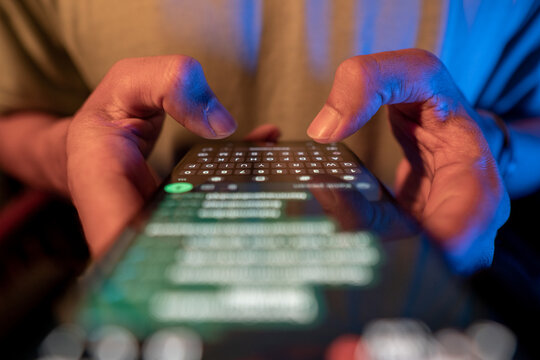 Close up view of man's hands typing a message on a smart phone, typing a text message, touching a touch screen keyboard. Concept of using messenger app. Online chat concept