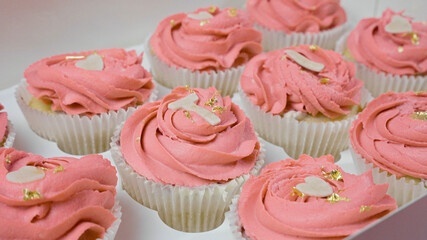 cupcakes with pink frosting in a box