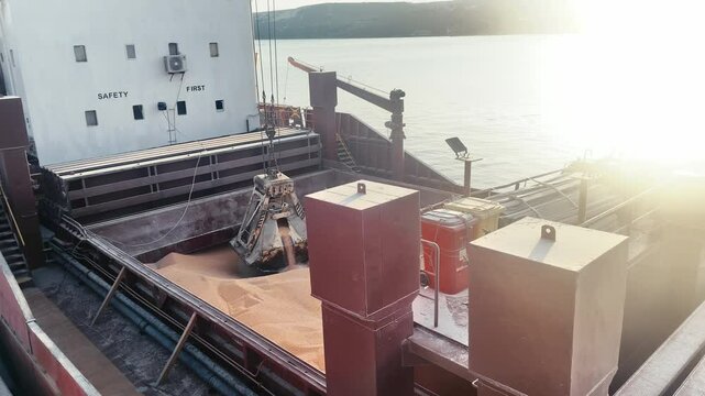  wheat unloading from bulker ship cargo hold in sea port. Trading and Transportation of agricultural commodities.