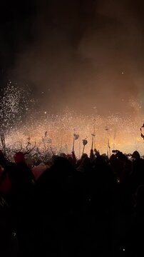 traditional catalan correfocs running in celebration with fireworks and people dressed like demons in barcelona city center, spain