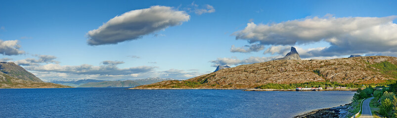 Naklejka premium Landscape, mountains and fjord with water, nature and horizon with clouds in sky, ecosystem and sustainability. Outdoor, sea and hill with forest, growth and coastal environment in summer in Norway