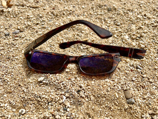 Lost Broken Sunglasses in Sand at the Beach Shore