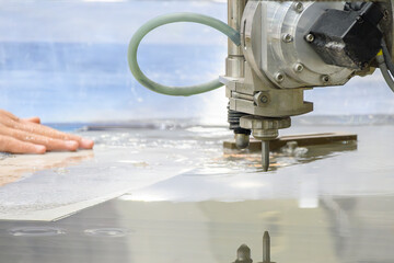 Close-up scene of multi-axis abrasive waterjet cutting machine cutting the aluminum plate.