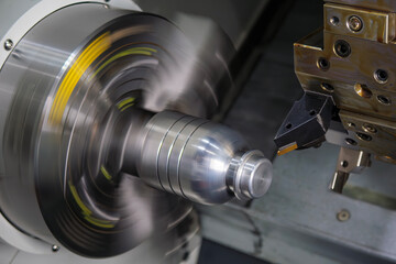 The  CNC lathe machine forming  cutting the metal shaft parts.