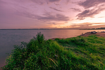 The background of the sea by the evening sea, with natural beauty (sea water, rocks, sky) and fishermen are fishing by the river bank, is a pleasure during travel.