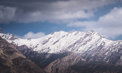 Fototapeta premium Panorama of mountain range of rocks with snow and glaciers in Pamir in Tajikistan mountains in cloudy weather, minimalistic landscape of high mountains for background
