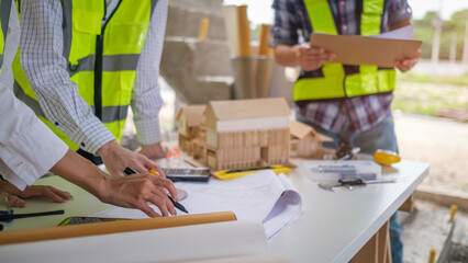 Architect and engineer construction workers working with blueprints construction site.