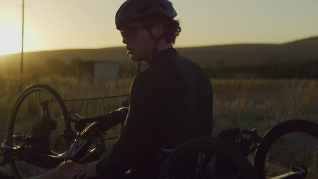 Para Athlete cycling at sunset and looking at the camera