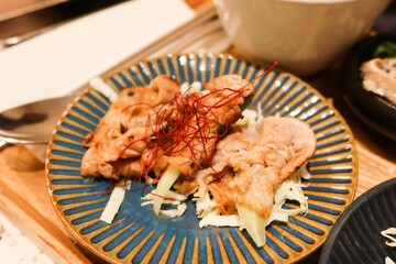 close up of Japanese style stir fried pork on a blue plate