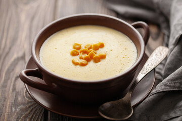 Delicious creamy corn soup in ceramic bowl on the table. Vegetarian food