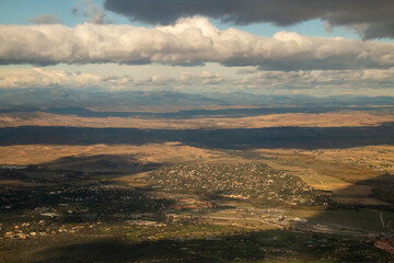 Urbanización Ciudad Santo Domingo en Algete y vista del valle del río Jarama, Madrid, España. Vista aérea desde un avión comercial del terreno, horizonte y las nubes.
