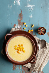 Delicious creamy corn soup in ceramic bowl on the table. Vegetarian food
